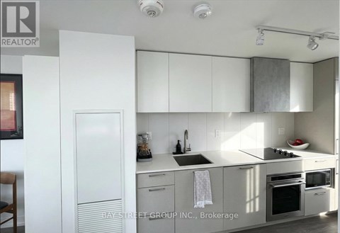 A kitchen with white cabinets and appliances.