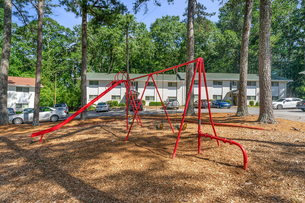 a swing set at a playground in front of a building
