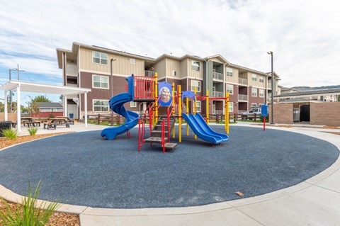 A playground with a blue slide and red and yellow climbing frame.