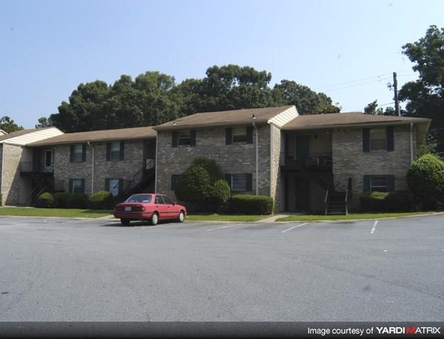 a red car parked in front of an apartment building