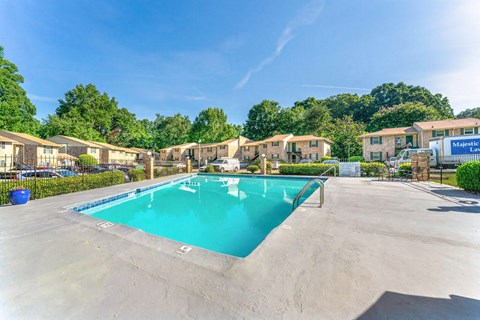 a swimming pool in a parking lot with apartments in the background