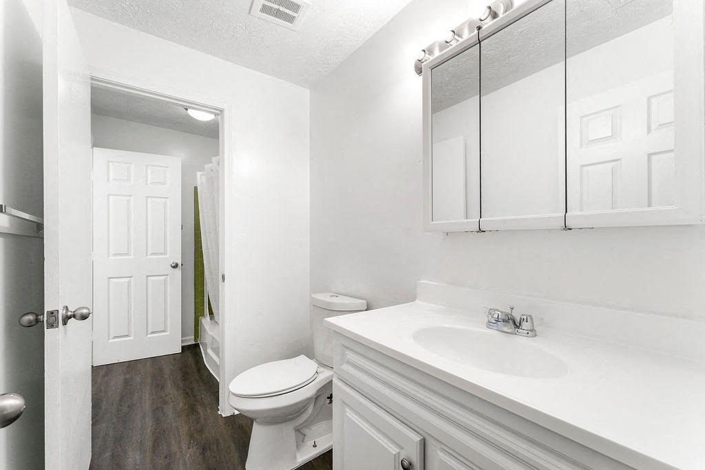 a white bathroom with a toilet and a sink