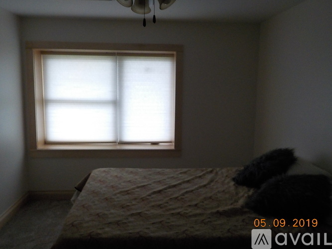 A bedroom with a bed and a window.