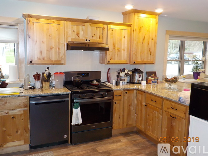 A kitchen with wooden cabinets and black appliances.