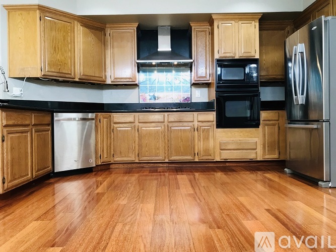 A kitchen with wooden cabinets and a black countertop.