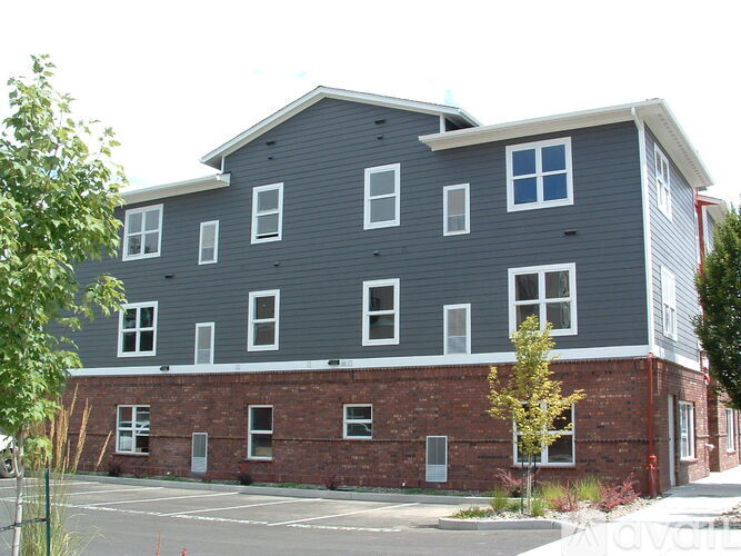 A grey building with a red fire hydrant in front.