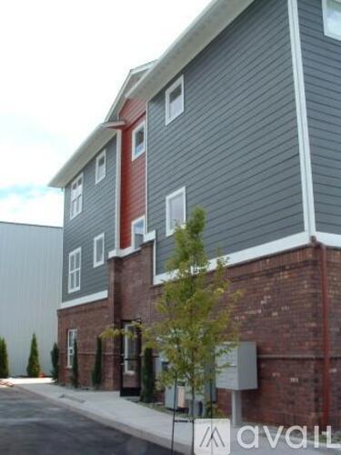 A grey building with a red brick section at the bottom.