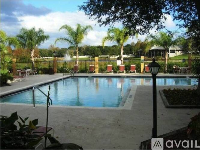 A pool surrounded by a fence and trees.