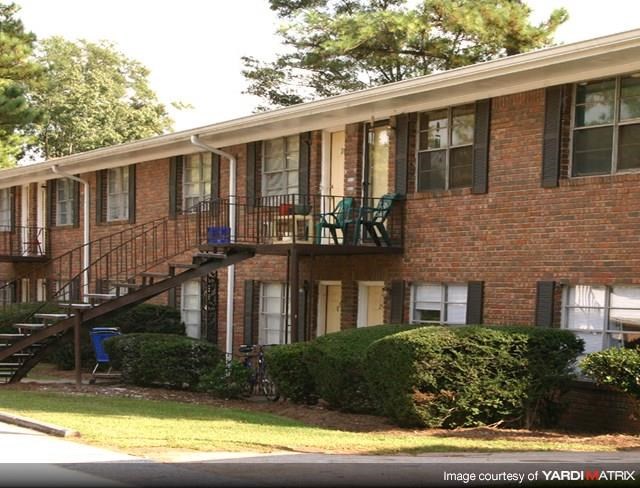 a brick apartment building with stairs and a balcony