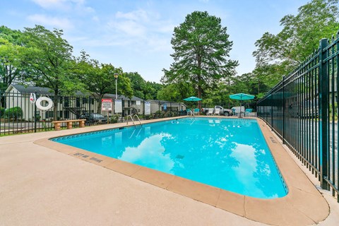 a swimming pool with a fence around it and trees