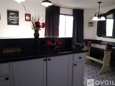 A kitchen with white cabinets and a black countertop.