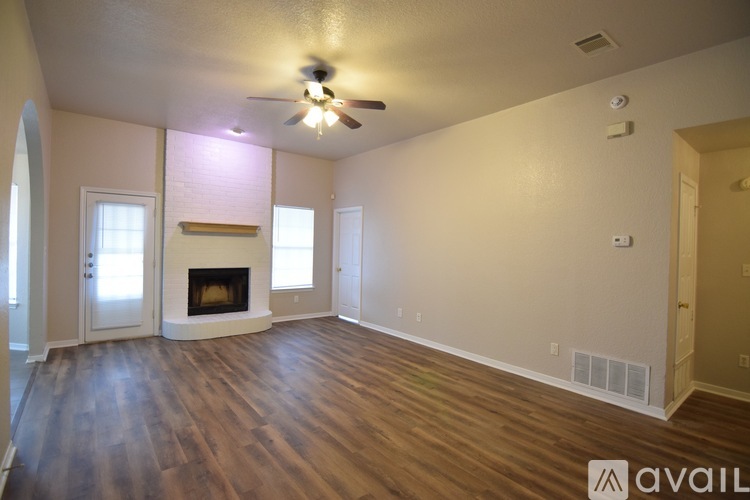 A spacious living room with a fireplace and hardwood floors.