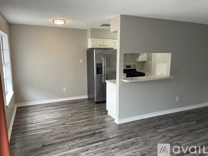 A kitchen area with a refrigerator and a countertop.