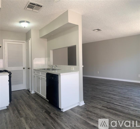 A kitchen with a white countertop and a black dishwasher.