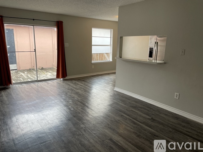 A room with a sliding glass door and a window with a white frame.