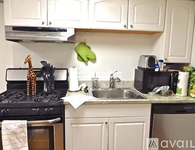 A kitchen with a black stove top and white cabinets.