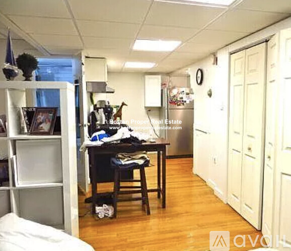 A kitchen area with a table and chairs in the middle.