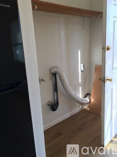 A white wall with a metal pipe running along it.