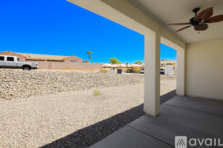 A clear blue sky meets a sunny patio with a fan.