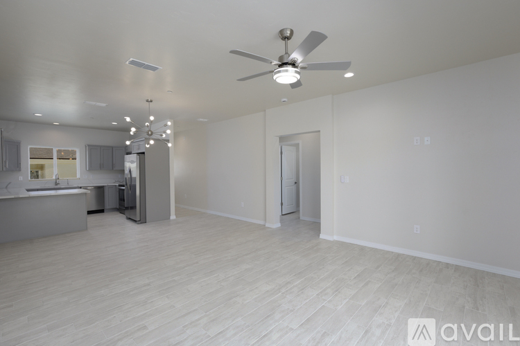 A spacious room with a ceiling fan and lighting fixture.