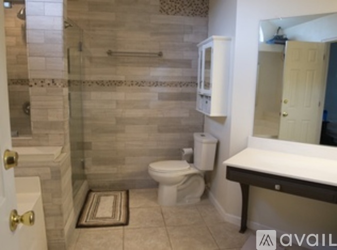 A bathroom with a toilet, sink, and walk-in shower.