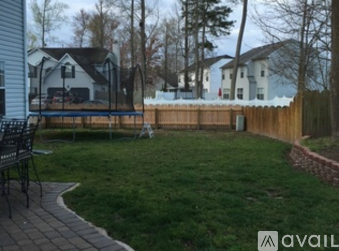 A backyard with a swing set and a wooden fence.