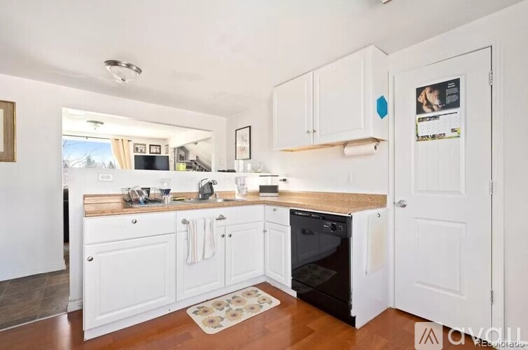 A kitchen with white cabinets and a wooden countertop.