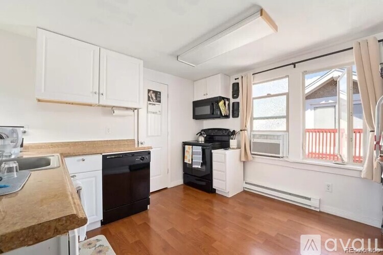 A kitchen with white cabinets and a wooden countertop.