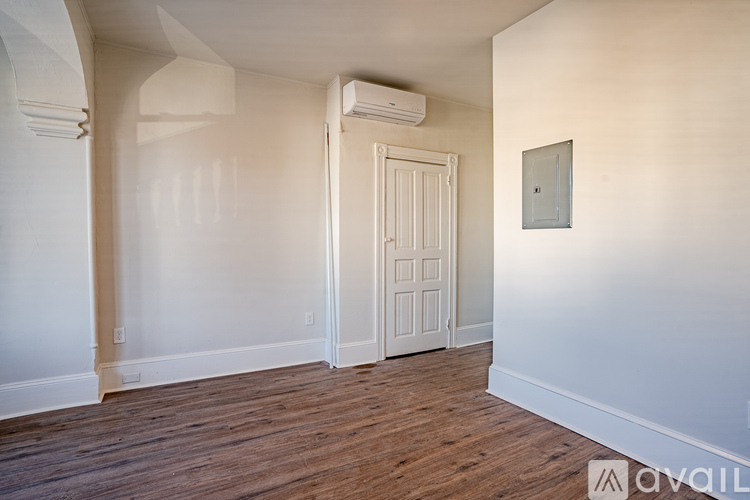 A room with a white door and a wall-mounted air conditioner unit.