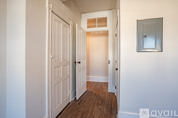 A hallway with a white door and a mirror on the wall.