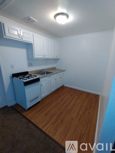 A kitchen with white cabinets and a blue wall.