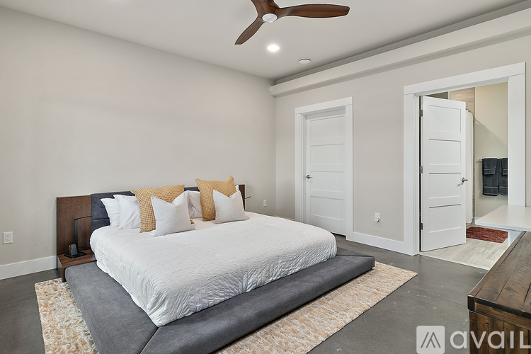A bedroom with a large bed and a ceiling fan.