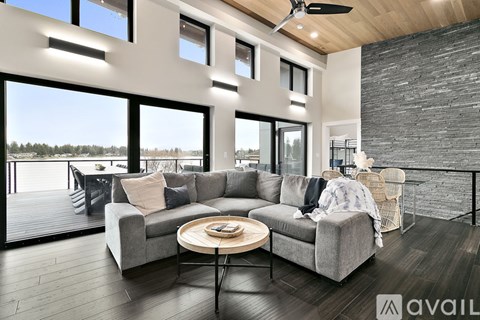 A modern living room with a grey sofa and a round wooden table.
