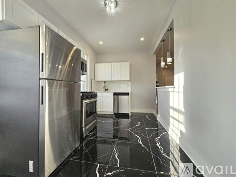 A modern kitchen with a marble floor and stainless steel appliances.