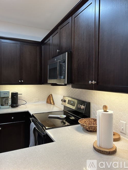 A kitchen with dark wood cabinets and a white countertop.
