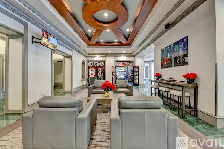 A living room with grey couches and a wooden ceiling.
