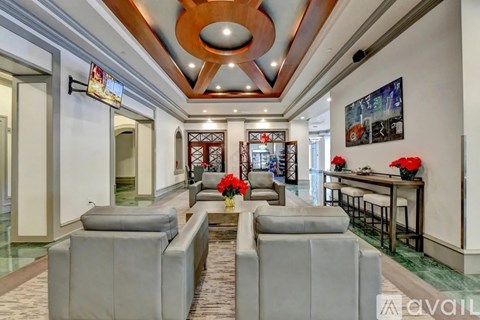 A living room with grey couches and a wooden ceiling.