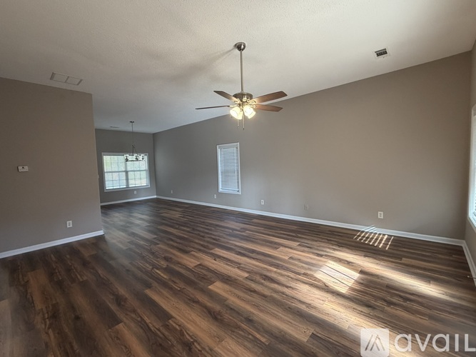 A room with wooden flooring and a ceiling fan.