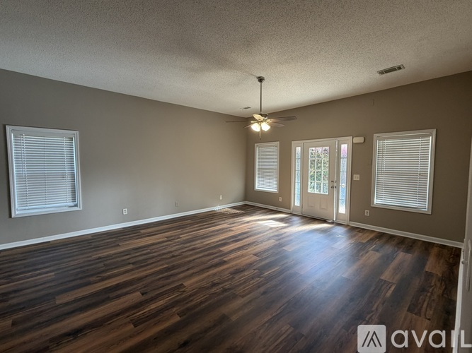 A room with wooden floors and a ceiling fan.