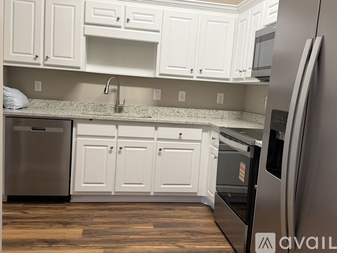 A kitchen with white cabinets and a granite countertop.