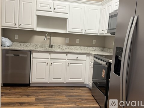 A kitchen with white cabinets and a granite countertop.