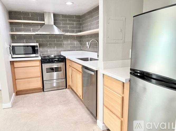 A kitchen with a stainless steel refrigerator, microwave, oven, and sink.