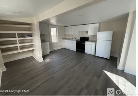 A kitchen with white appliances and wooden floors.