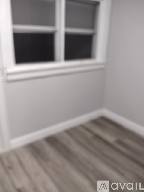 A room with a window and wooden flooring.