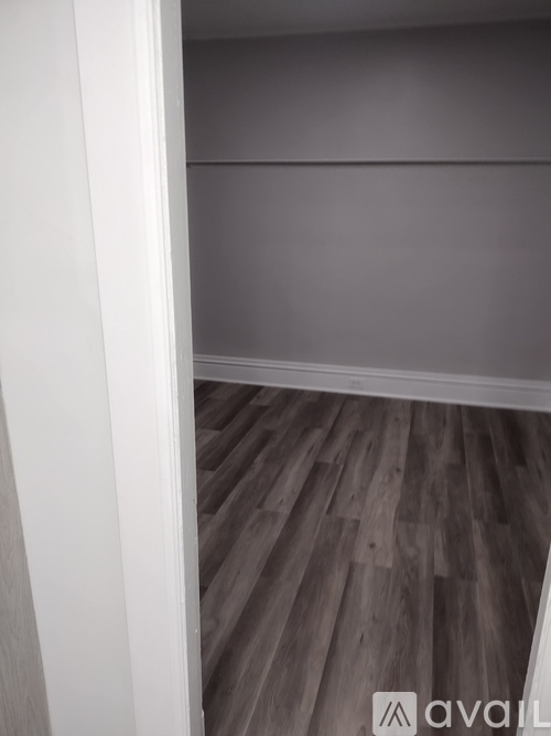 A room with wooden flooring and a white wall.