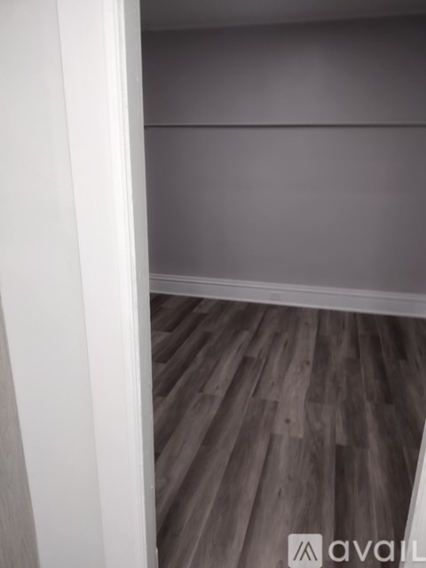 A room with wooden flooring and a white wall.