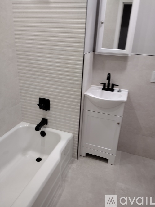 A white bathroom with a tub, sink and medicine cabinet.