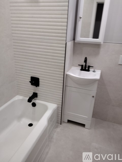 A white bathroom with a tub, sink and medicine cabinet.