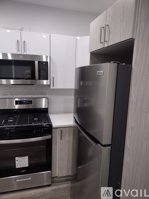 A modern kitchen with a stainless steel refrigerator and microwave.