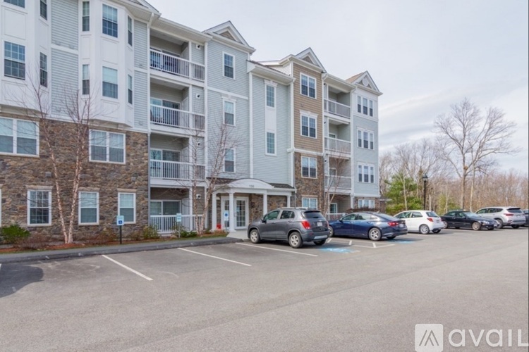 A large apartment building with a parking lot in front.